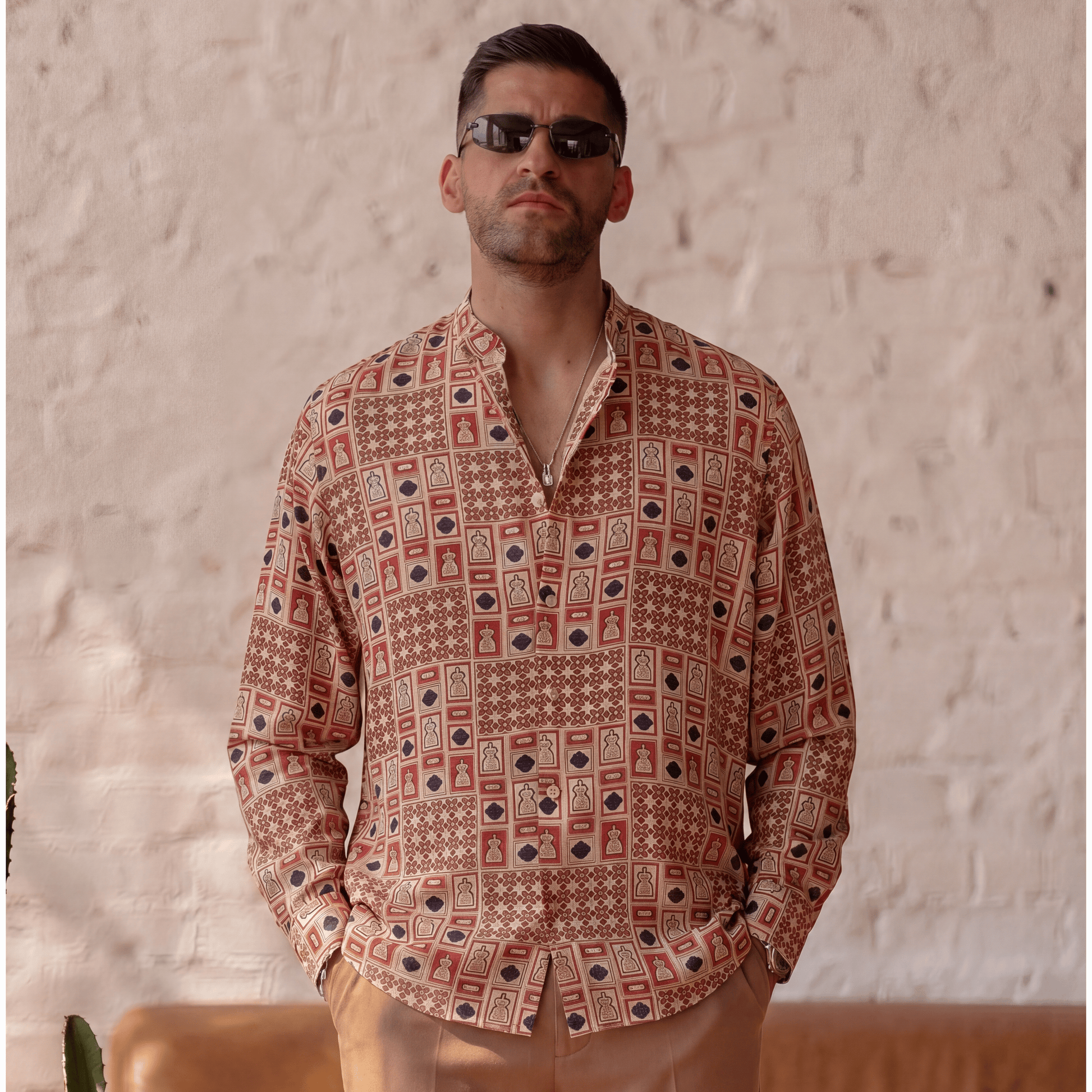 Fluid drape of long-sleeve printed viscose shirt styled with light brown trousers