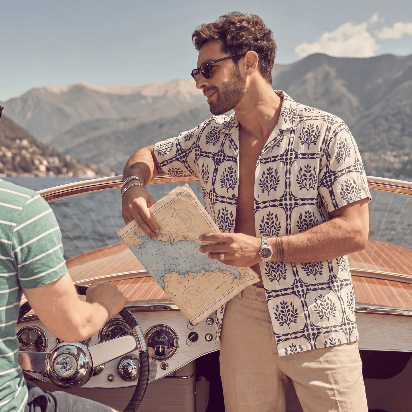 Man wearing white linen Cuban shirt with navy geometric leaf print on boat