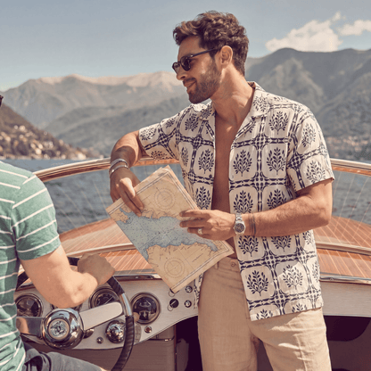 Man wearing white linen Cuban shirt with navy geometric leaf print on boat