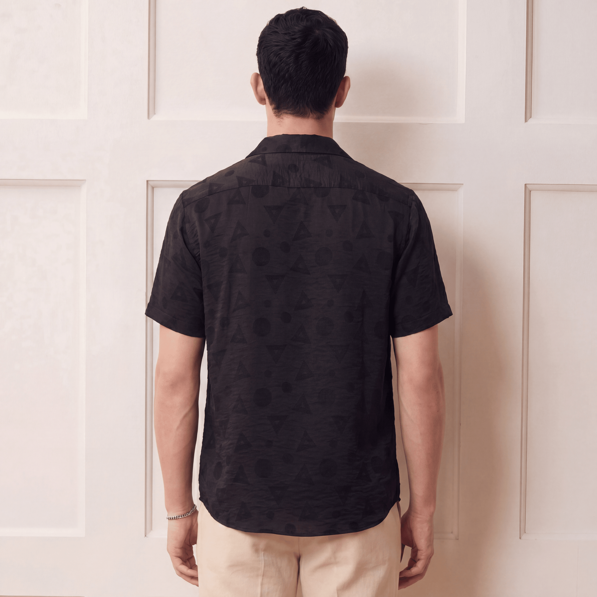 Back view of black viscose jacquard shirt with curved hem and geometric weave