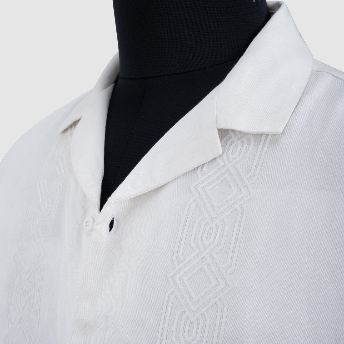 Close-up of white Tencel Cuban collar shirt with vertical embroidery detail
