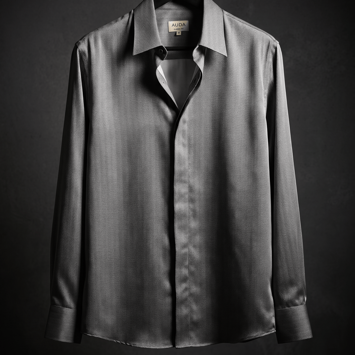 A dark gray long-sleeve button-down shirt with a subtle vertical texture, hanging on a black hanger against a dark gray background.