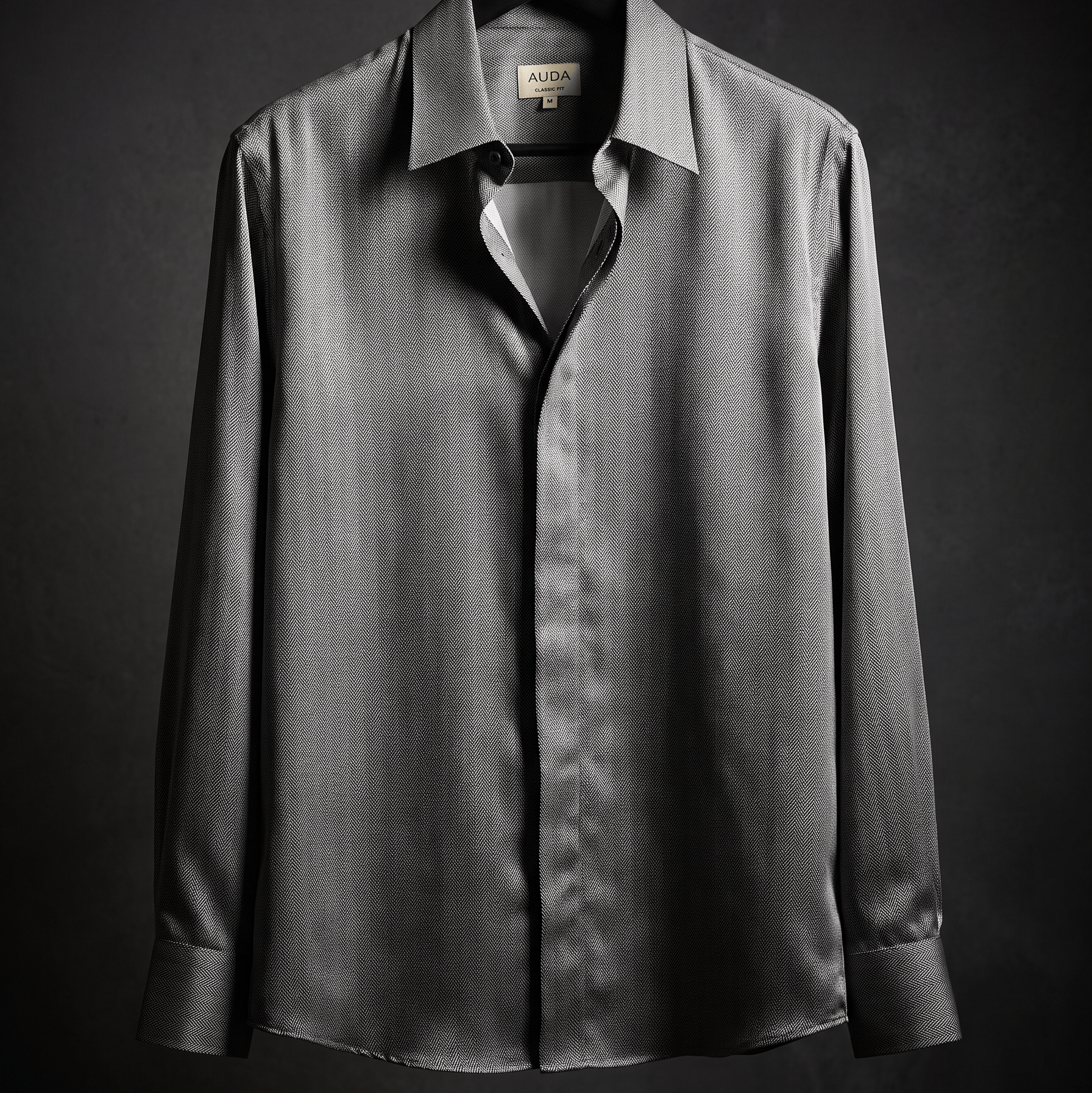 A dark gray long-sleeve button-down shirt with a subtle vertical texture, hanging on a black hanger against a dark gray background.