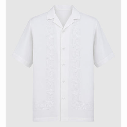Flat lay of white short sleeve shirt with symmetrical front embroidery motifs