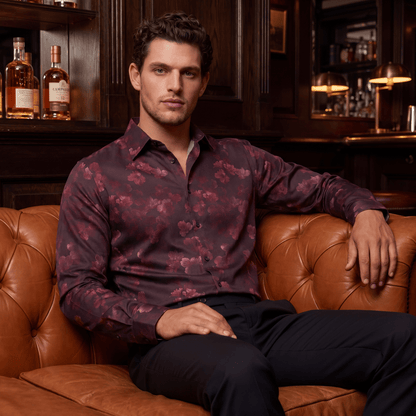 Fluid drape of Midnight Rose floral evening shirt on man seated