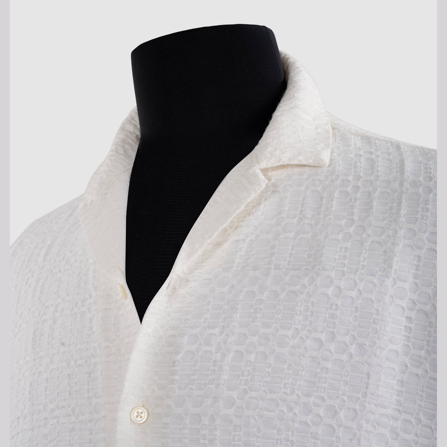Close-up of white viscose jacquard shirt showing geometric weave detail