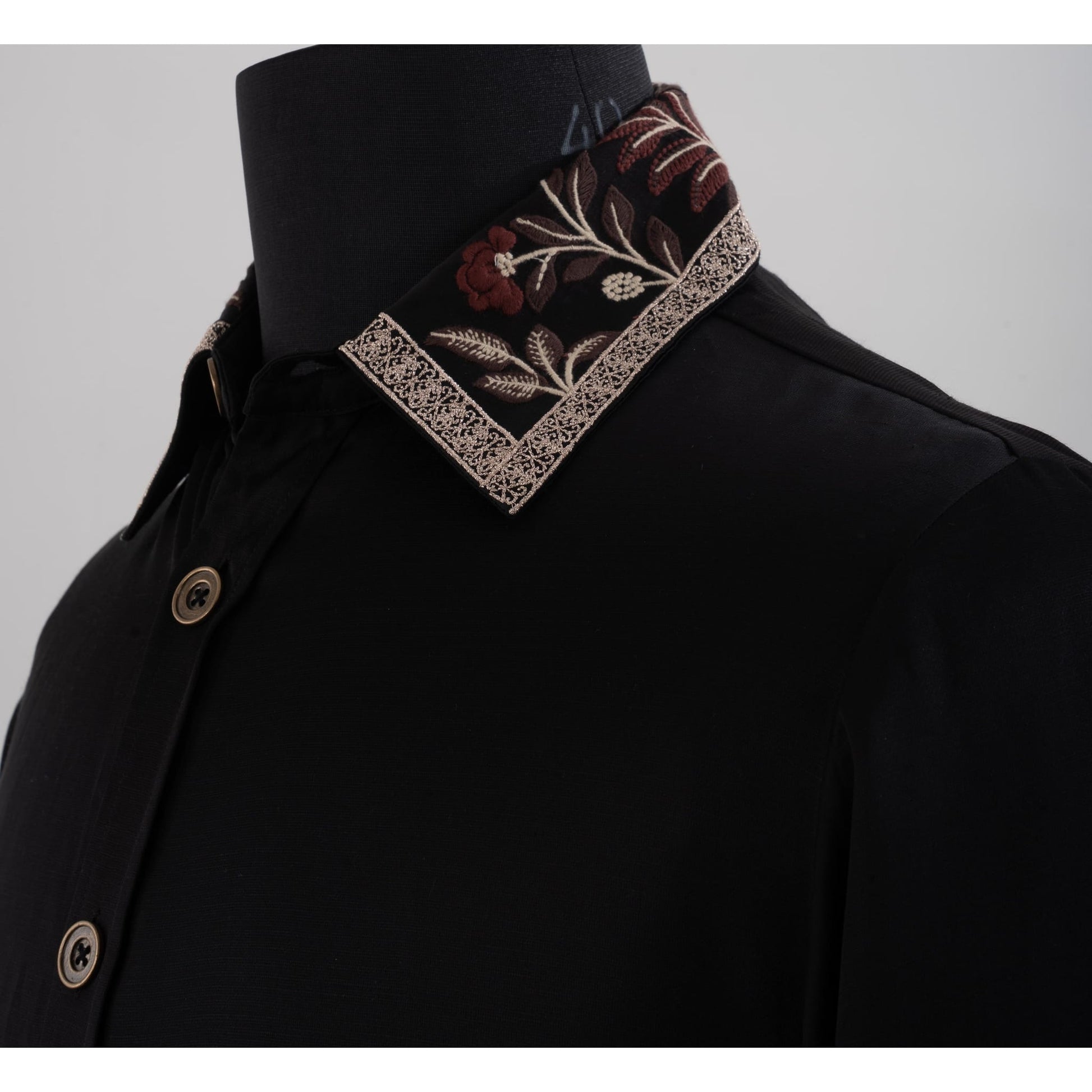 Close-up of black shirt collar featuring brown beige floral embroidery and lace trim