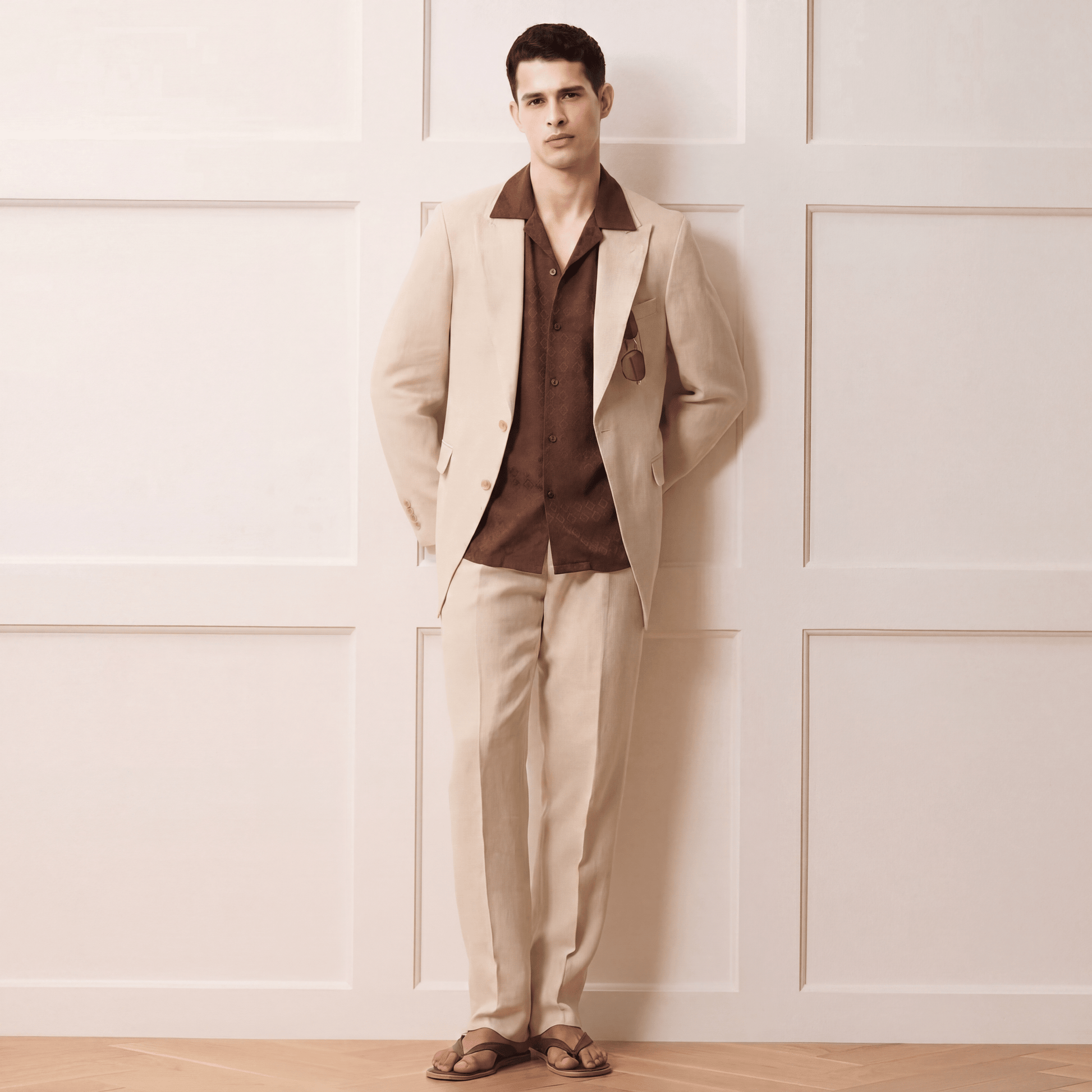 Man wearing brown jacquard Cuban shirt under beige suit jacket