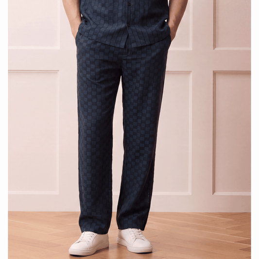 Relaxed dark navy check-patterned trousers with hybrid waistband worn by model in casual-luxury outfit