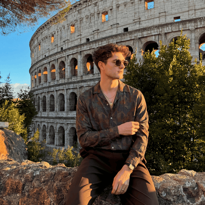 Man wearing abstract print long sleeve shirt outdoors at Colosseum in Rome
