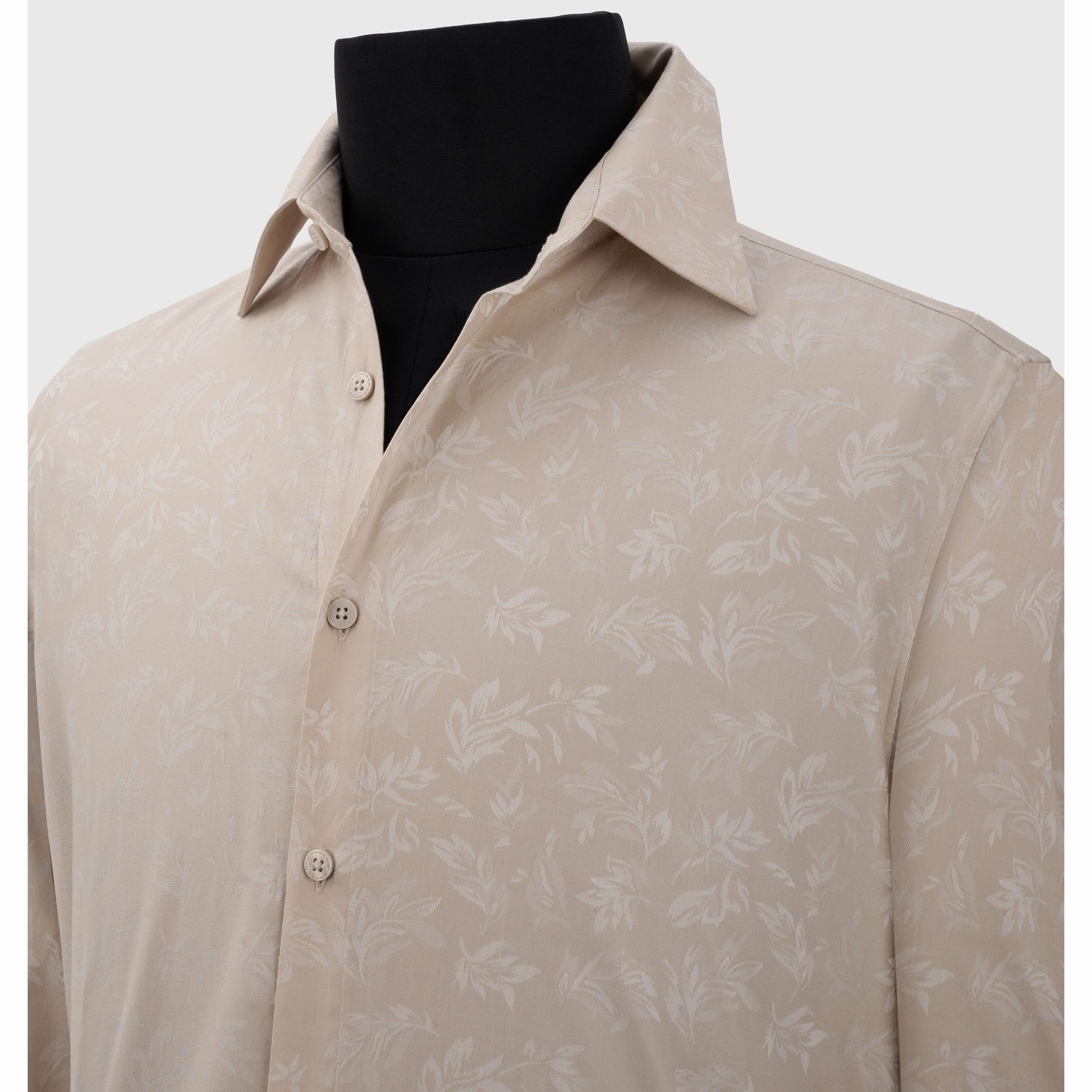 Close-up of light beige cotton shirt featuring subtle white leafy jacquard weave detail